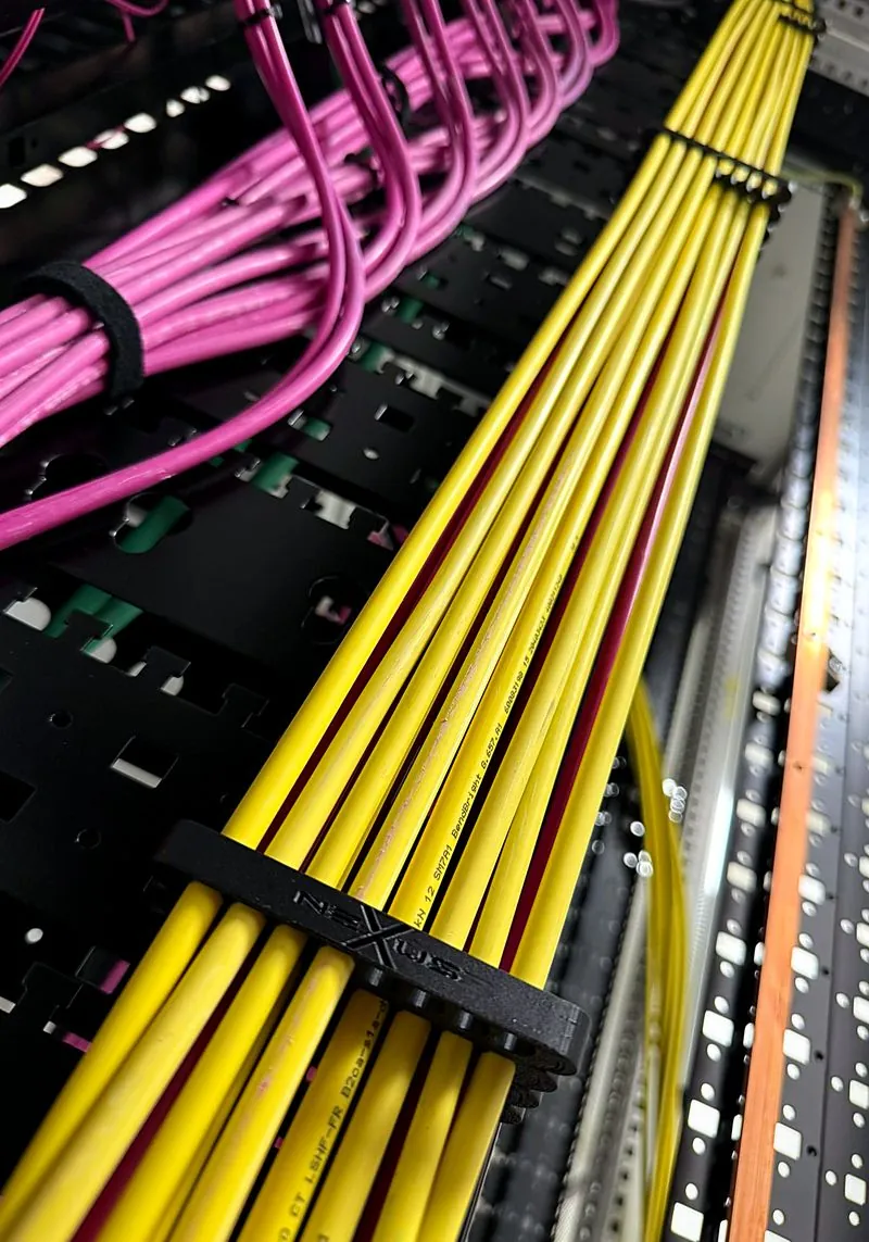 Cablaggio in fibra in un data center, cavi gialli ordinati nel pettine con logo Nexus